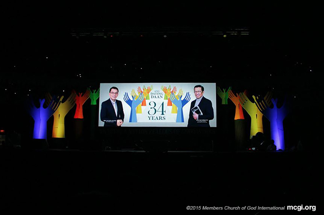 The logo of Ang Dating Daan's 34th anniversary with MCGI Leaders Bro. Daniel Razon (left) and Bro. Elise Soriano (right) being shown on the large LED screen. (Photo courtesy of PVI)