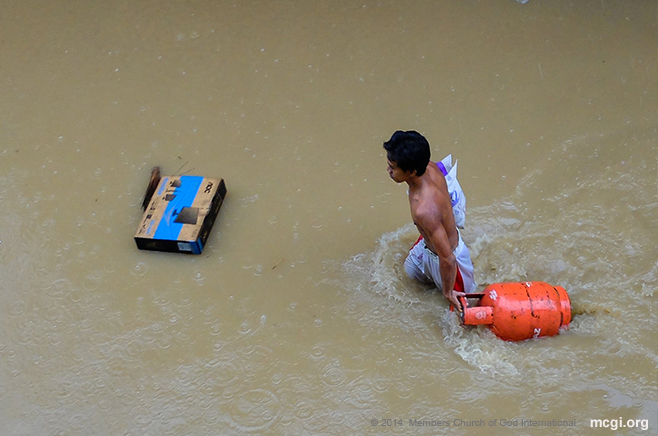 A man pulls a gas tank on a flooded street in Marikina, Philippines during the siege of Typhoon Fung Wong (Mario) on September 19, 2014. (Photo courtesy of Photoville Intenational)