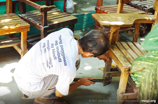  An elderly brother repairing a worn-down classroom chair during a Brigada Eskwela project held in Maria Concepcion Cruz High School in Pateros, Manila. (Photo courtesy of Photoville International)