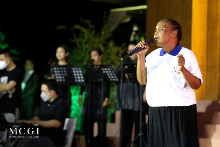 A sister singing during MCGI Serbisyong Kapatiran segment Harana sa Kapatiran
